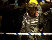 A man wraps himself in an emergency foil blanket provided by rescue services following an incident at the Apollo Theatre, in London's Shaftesbury Avenue, Thursday evening, Dec. 19, 2013 during a performance , with police saying there were "a number" of casualties. It wasn't immediately clear if the roof, ceiling or balcony had collapsed. The London Fire Brigade said the theatre was almost full, with around 700 people watching the performance. A spokesman added: "It's thought between 20 and 40 people were injured." (AP Photo by Joel Ryan, Invision)