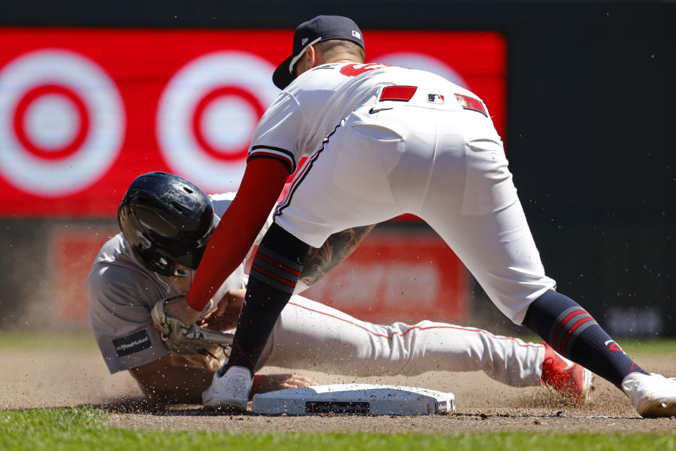 Minnesota Twins third baseman Jose Miranda, right, tags Boston Red Sox's Reese McGuire who was attempting to steal third in the fifth inning of a baseball game Sunday, May 5, 2024, in Minneapolis. Initially called out, the umpires determined McGuire was safe upon review. (AP Photo/Bruce Kluckhohn)