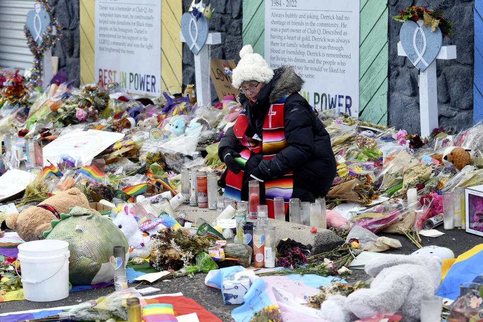 Rev. Paula Stecker of the Christ the King Lutheran Church tidies up a memorial outside Club Q following last week's mass shooting at the gay nightclub, in Colorado Springs, Colo., Tuesday, Nov. 29, 2022. (AP Photo/ Thomas Peipert)