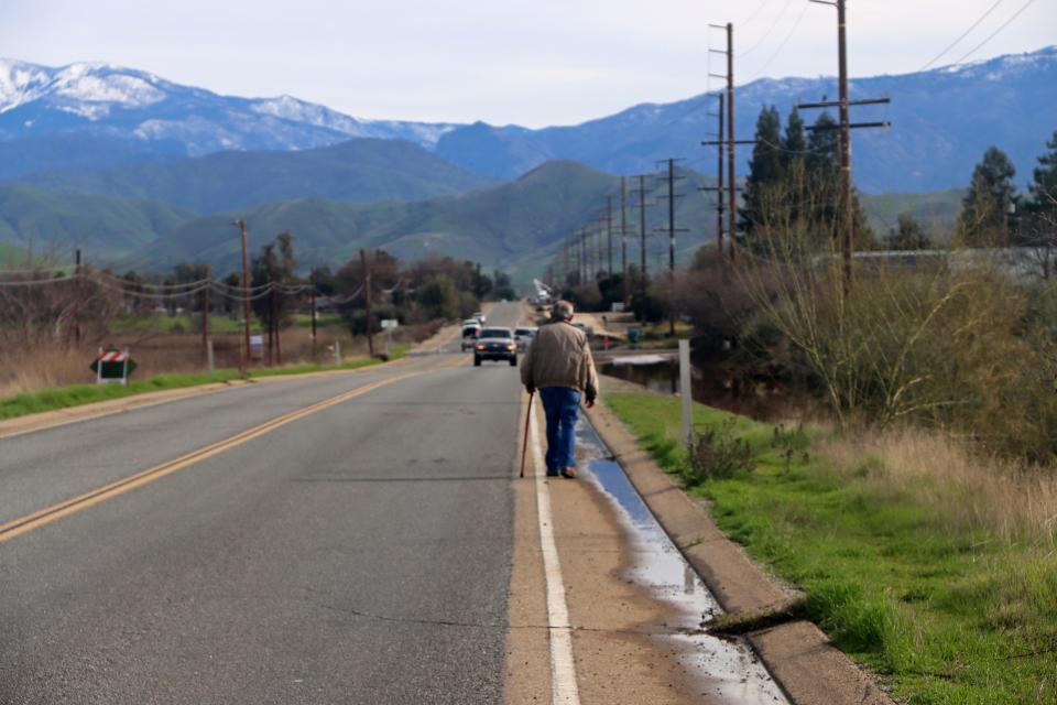 Victor Sanchez walks along the street neighboring his family's property for the first time since a series of storms flooded the area. Sanchez and his son Ubaldo lost multiple vehicles and tractors over the span of just a few hours.