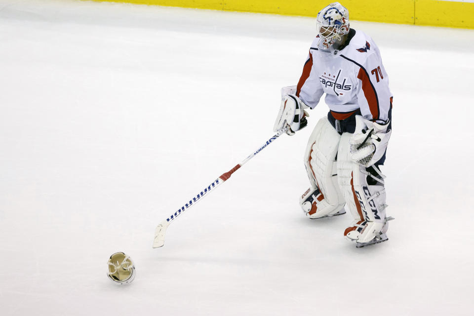 Washington Capitals goaltender Braden Holtby (70) takes a helmet off the ice during the second period of an NHL hockey playoff game against the Philadelphia Flyers Thursday, Aug. 6, 2020, in Toronto. (Cole Burston/The Canadian Press via AP)