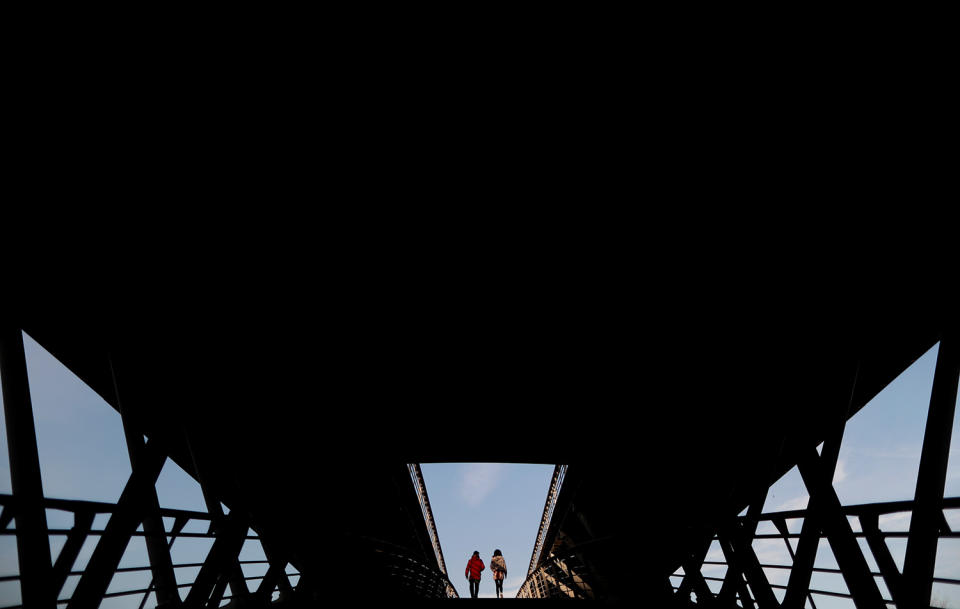 <p>People are silhouetted as they cross the Solferino Bridge over the Seine River on a mild and sunny winter afternoon in Paris, Feb. 17, 2017. (Photo: Christian Hartmann/Reuters) </p>