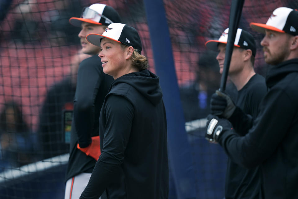 Baltimore Orioles' Jackson Holliday, second from left, smiles while watching batting practice with teammates prior to his first major league baseball game against the Boston Red Sox, Wednesday, April 10, 2024, in Boston. Holliday, the son of seven-time All-Star Matt Holliday, is schedule to play second base in Wednesday game. (AP Photo/Charles Krupa)