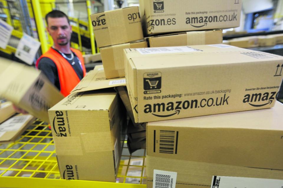 Amazon workers have begun to vote in a ballot to join GMB union (Pictured: A worker prepares packages for delivery at an Amazon warehouse on September 4, 2014 in Brieselang, Germany. Photo by Sean Gallup/Getty Images)