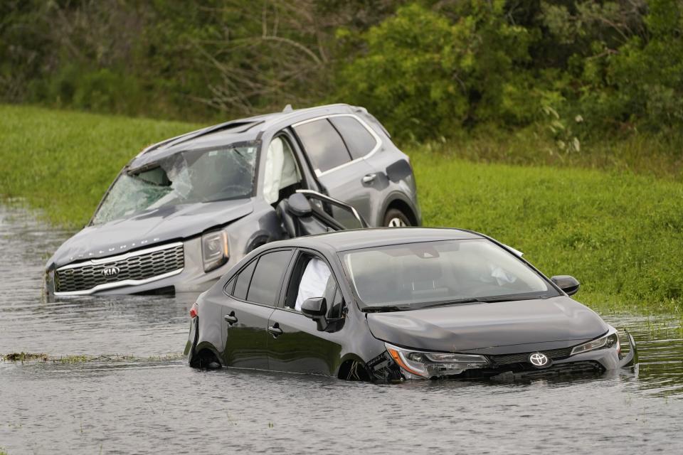 Vehicles sit in floodwaters on the side of Interstate 75 in North Port, Fla., following Hurricane Ian, Thursday, Sept. 29, 2022. (AP Photo/Steve Helber)