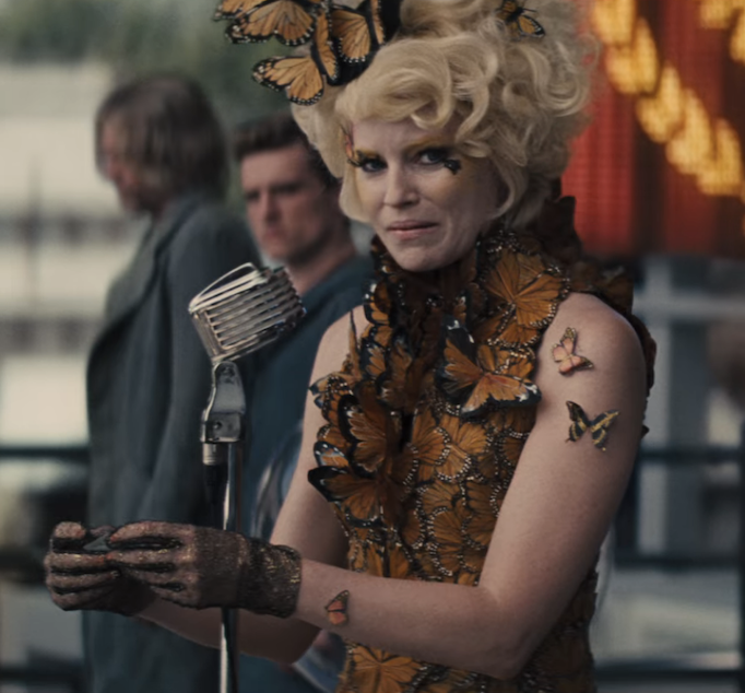 I don't want to strain a muscle with this reach, but do the butterflies symbolize the transformation — chrysalis style — of Effie from a casually cruel and vapid citizen of the Capitol to the more empathetic, self-aware character she becomes in the latter half of the series? Movie Effie's character arc is as skillfully executed as her wardrobe, and the devastation of having to reap Katniss and Peeta again, along with this dress, stand out to me as a philosophical turning point for her. 