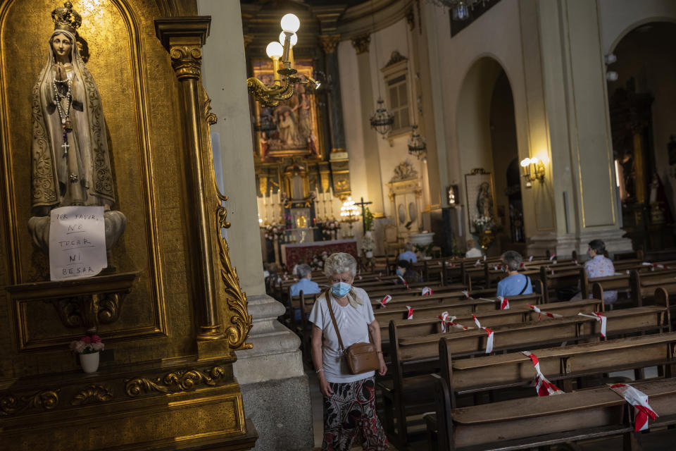 Catholic worshippers, wearing face masks protection to prevent the spread of the coronavirus, attend a mass at the San Ildefonso church in Madrid, Spain, Sunday, May 31, 2020. (AP Photo/Bernat Armangue)