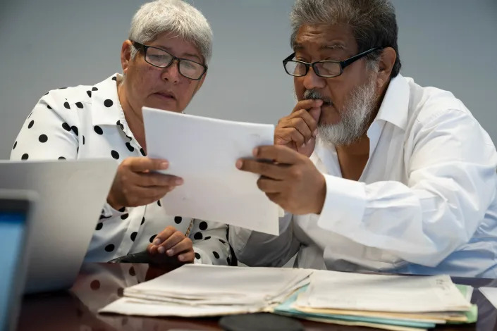 María de Jesús Peters (left) and Juan de Dios García Davish, Mexican journalists, look through documents for the first threat they reported to the Chiapas attorney's office, while being interviewed at the Arizona Republic in Phoenix.