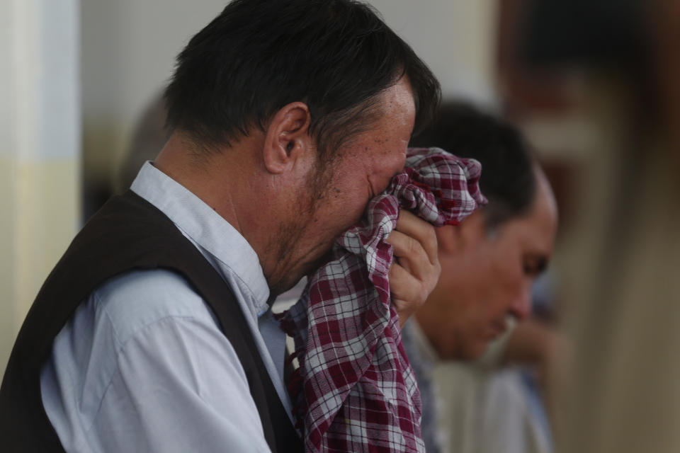 Men mourn for the victims of the Dubai City wedding hall bombing during a memorial service at a mosque in Kabul, Afghanistan, Tuesday, Aug. 20, 2019. Hundreds of people have gathered in mosques in Afghanistan's capital for memorials for scores of people killed in a horrific suicide bombing at a Kabul wedding over the weekend. (AP Photo/Rafiq Maqbool)