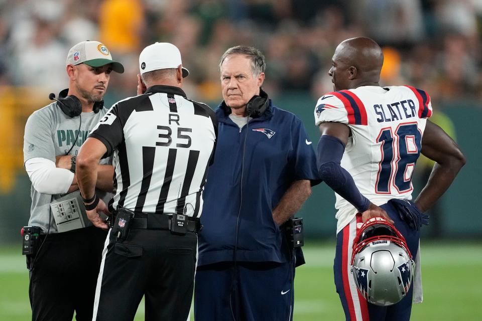 GREEN BAY, WISCONSIN - AUGUST 19: Referee John Hussey #35 talks with head coach Matt LaFleur of the Green Bay Packers (L) and head coach Bill Belichick of the New England Patriots before the preseason game was suspended at Lambeau Field on August 19, 2023 in Green Bay, Wisconsin. (Photo by Patrick McDermott/Getty Images)