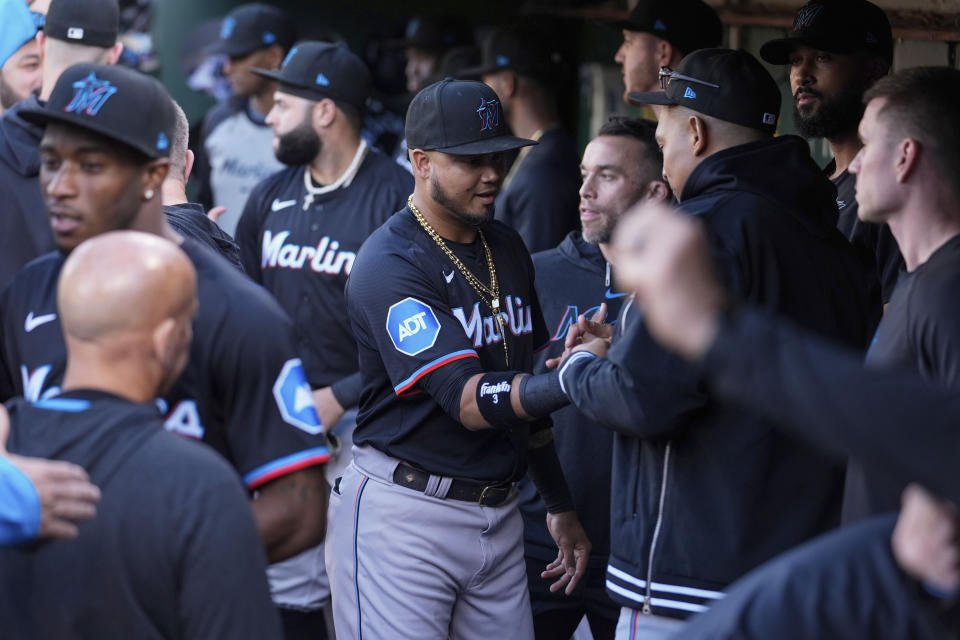 Miami Marlins' Luis Arraez, center, shakes hands with teammates in the dugout after being traded to the San Diego Padres before the team's baseball game against the Oakland Athletics, Friday, May 3, 2024, in Oakland, Calif. (AP Photo/Godofredo A. Vásquez)