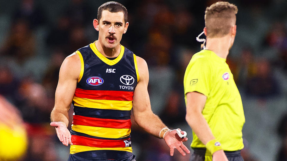 Adelaide Crows forward Taylor Walker is pictured speaking to an umpire.
