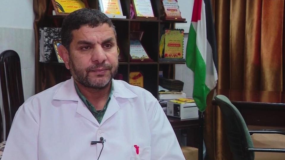 Dr Marwan al-Hams wearing a medical coat and sitting down in his office at his hospital in Rafah