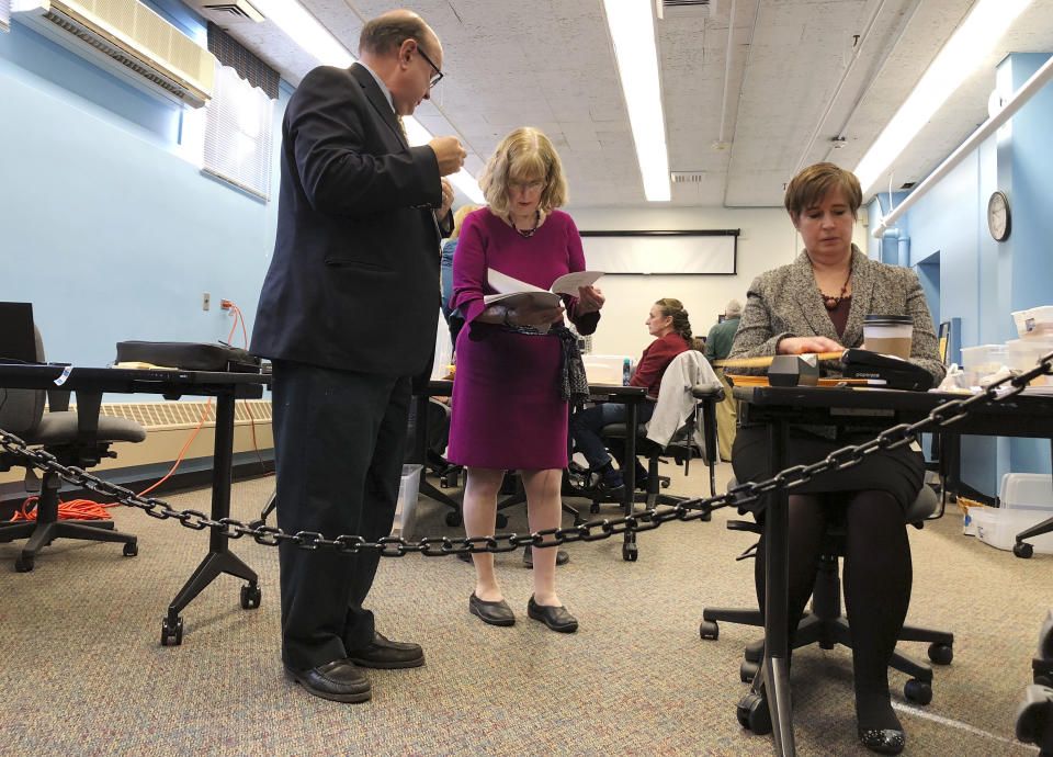 Maine election officials, including Democratic Secretary of State Matt Dunlap, left, and Deputy Secretary of State Julie Flynn, center, began counting ballots on Friday, Nov. 9, 2018, in Augusta for the Second Congressional District's House election. The election is the first congressional race in American history to be decided by the ranked-choice voting method that allows second choices. (AP Photo/Marina Villeneuve)