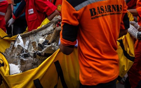 Search and rescue personnel examine recovered debris and personal items from Lion Air flight JT 610 - Credit: Getty Images AsiaPac