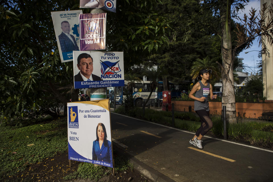 A woman jogs past political campaign posters at Reforma avenue in Guatemala City, early Saturday, June 15, 2019. The road to Sunday's presidential election in Guatemala has been a chaotic flurry of court rulings and shenanigans, illegal party-switching and allegations of malfeasance that torpedoed the candidacies of two of the top three candidates. (AP Photo/Oliver de Ros)