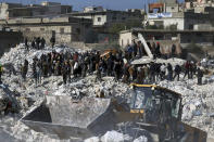 Rescuers and residents search through the rubble of collapsed buildings in the town of Harem near the Turkish border, Idlib province, Syria, Wednesday, Feb. 8, 2023. With the hope of finding survivors fading, stretched rescue teams in Turkey and Syria searched Wednesday for signs of life in the rubble of thousands of buildings toppled by a catastrophic earthquake. (AP Photo/Ghaith Alsayed)