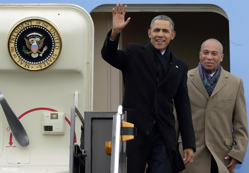 President Barack Obama waves as he is followed by Massachusetts Gov. Deval Patrick, right, upon his arrival on Air Force One at Logan Airport, Wednesday, March 5, 2014, in Boston. Obama traveled to Boston to attend a pair of Democratic fundraisers. (AP Photo/Charles Krupa)