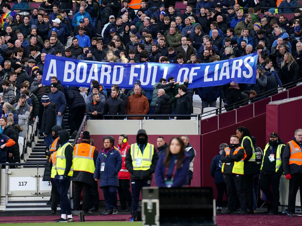 21 Janaury 2023: Everton fans hold up banners protesting against the board of directors during their Premier League match against West Ham at the London Stadium (PA)