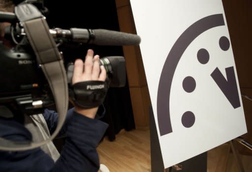 A television photojournalist records the Doomsday Clock following an announcement by the Bulletin of Atomic Scientists (BAS) announcing that it has moved the hands to five minutes to midnight, up one minute from two years ago, at the American Association for the Advancement in Washington, DC,