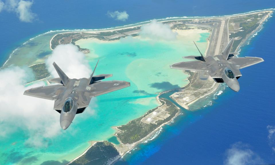 Two F-22 Raptors fly over Wake Island as part of a rapid deployment June 21, 2013.