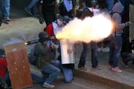 An anti-government protester fires a rudimentary mortar at the police during a protest against President Nicolas Maduro's government in Caracas April 12, 2014. Maduro cautioned opposition leaders to keep their expectations modest on Thursday as he hosted them for mediated talks intended to stem two months of deadly political unrest. REUTERS/Carlos Garcia Rawlins (VENEZUELA - Tags: POLITICS CIVIL UNREST TPX IMAGES OF THE DAY)