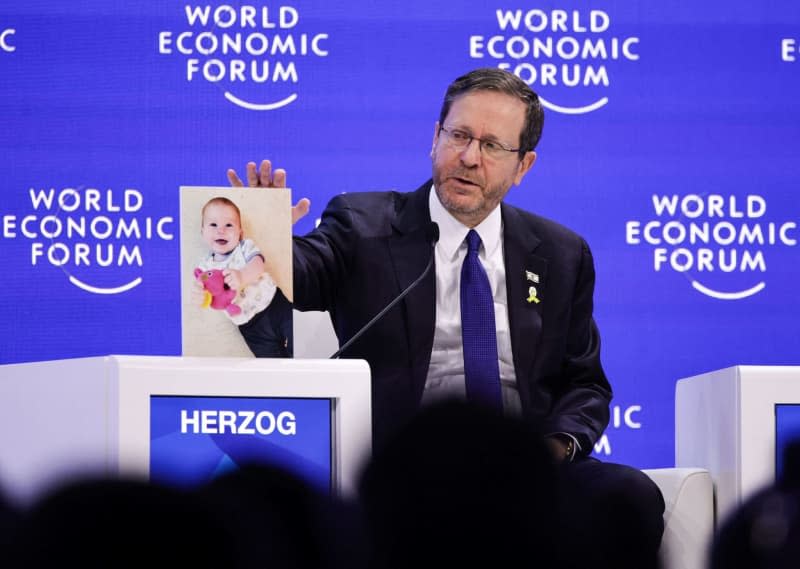 President of Israel Isaac Herzog shows a picture of a small child at an event during the World Economic Forum Annual Meeting 2024 in Davos. Hannes P. Albert/dpa