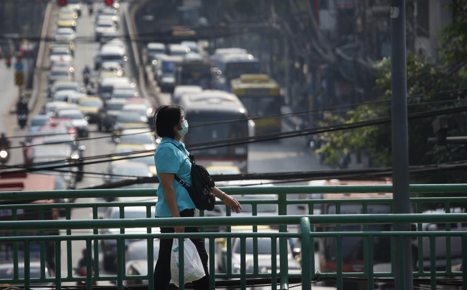 A pedestrian wears a protective mask on a flyover bridge during poor air quality in Bangkok, Thailand, Monday, Jan. 14, 2019. Unusually high levels of smog worsened by weather patterns are raising alarm across Asia. (AP Photo/Sakchai Lalit)