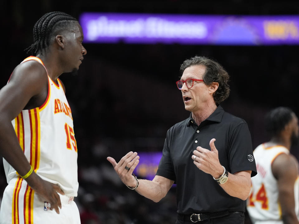 Atlanta Hawks head coach Quin Snyder talks to Atlanta Hawks center Clint Capela (15) during the first half of an NBA basketball game against the Portland Trail Blazers Wednesday, March 27, 2024, in Atlanta. (AP Photo/John Bazemore)