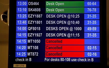 Cancelled flights are seen on screen at Manchester Airport