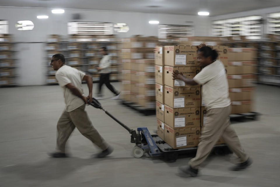 Trabajadores electorales trasladan máquinas de voto electrónico en un centro de distribución en Río de Janeiro, Brasil, el sábado 1 de octubre de 2022. (AP Foto/Matias Delacroix)