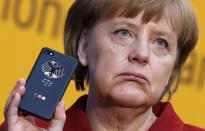 RNPS - PICTURES OF THE YEAR 2013 - German Chancellor Angela Merkel holds a BlackBerry Z10 smartphone featuring high security Secusite software, used for governmental communication, at the booth of Secusmart during her opening tour at the CeBit computer fair in Hanover March 5, 2013. REUTERS/Fabrizio Bensch (GERMANY - Tags: BUSINESS POLITICS TELECOMS TPX)