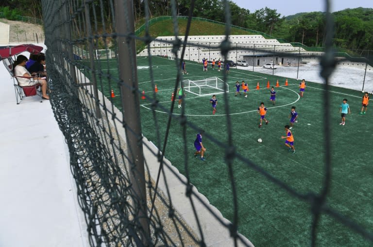 Parents watch young South Korean football students on the pitch at SON Football Academy