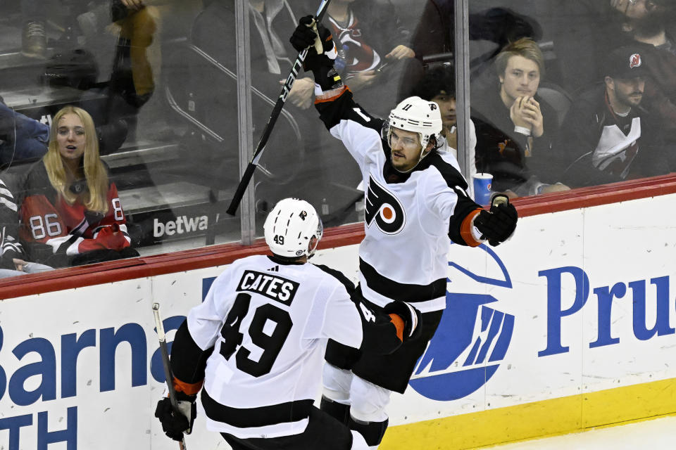 Philadelphia Flyers right wing Travis Konecny (11) celebrates his goal with left wing Noah Cates (49) during the third period of an NHL hockey game against the New Jersey Devils, Thursday, Dec. 15, 2022, in Newark, N.J. The Flyers defeated the Devils 2-1. (AP Photo/Bill Kostroun)