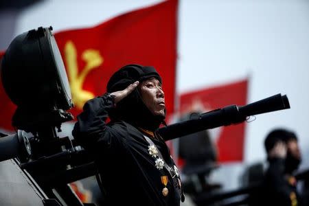 A soldier salutes from atop an armoured vehicle as it drives past the stand with North Korean leader Kim Jong Un during a military parade marking the 105th birth anniversary of country's founding father Kim Il Sung, in Pyongyang April 15, 2017. REUTERS/Damir Sagolj/Files