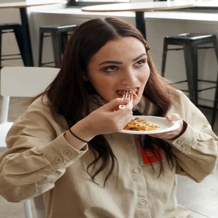 A woman eating pad Thai.