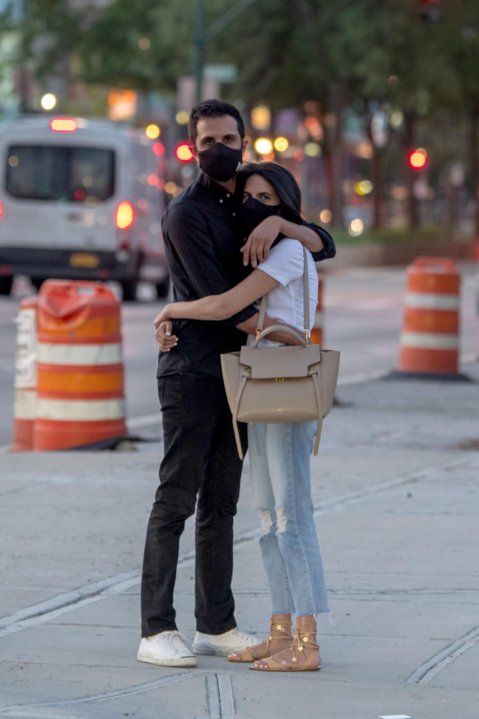 NEW YORK, NEW YORK - JULY 21: A couple wearing masks are seen hugging on the sidewalk as the city enters Phase 4 of re-opening following restrictions imposed to slow the spread of coronavirus on July 21, 2020 in New York City. The fourth phase allows outdoor arts and entertainment, sporting events without fans and media production. (Photo by Alexi Rosenfeld/Getty Images)