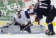 Slovakia's goalie Richard Sabol makes a save on Nicolas Kerdiles (R) of the U.S. during the second period of their IIHF World Junior Championship ice hockey game in Malmo, Sweden, December 28, 2013. REUTERS/Alexander Demianchuk (SWEDEN - Tags: SPORT ICE HOCKEY)