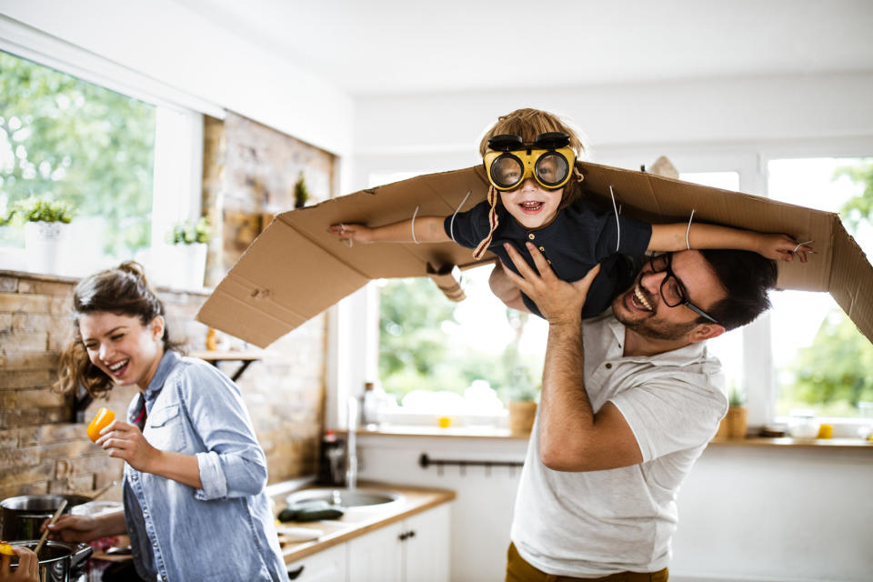 parents and their kid using cardboard as wings