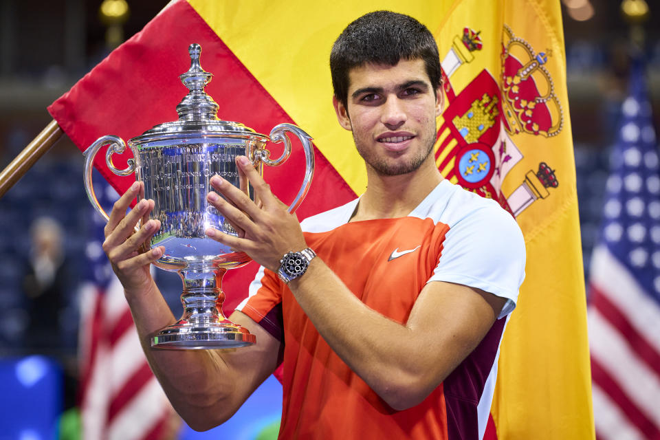 Carlos Alcaraz (pictured) smiles with the US Open trophy.