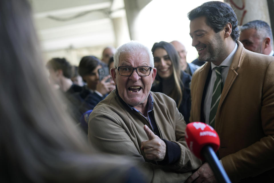 A supporter, center, of Andre Ventura, right, leader of populist and nationalist party Chega! (in English, Enough!) turns to journalists to utter insults at members of Portugal's two main political parties, during a Chega campaign action in Almada, Portugal, south of Lisbon, Friday, Feb. 23, 2024. Ventura has been riding in third place in opinion polls and could be cast in the role of kingmaker after Portugal's March 10 general election, if his political influence grows. (AP Photo/Armando Franca)