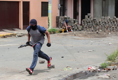 A demonstrator holds a shotgun near a barricade during a protest against the government of Nicaraguan President Daniel Ortega in Masaya, Nicaragua June 19, 2018. REUTERS/Oswaldo Rivas