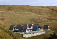 Scandinavian-style houses stand in a remote glen on the Shetland Islands April 2, 2014. REUTERS/Cathal McNaughton