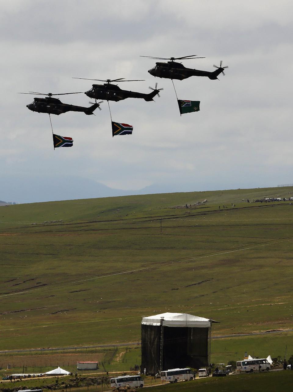 Army helicopters carry South African flags over the burial ground of late former South African President Nelson Mandela during his funeral in Qunu, December 15, 2013 REUTERS/Yannis Behrakis (SOUTH AFRICA - Tags: POLITICS OBITUARY SOCIETY MILITARY)