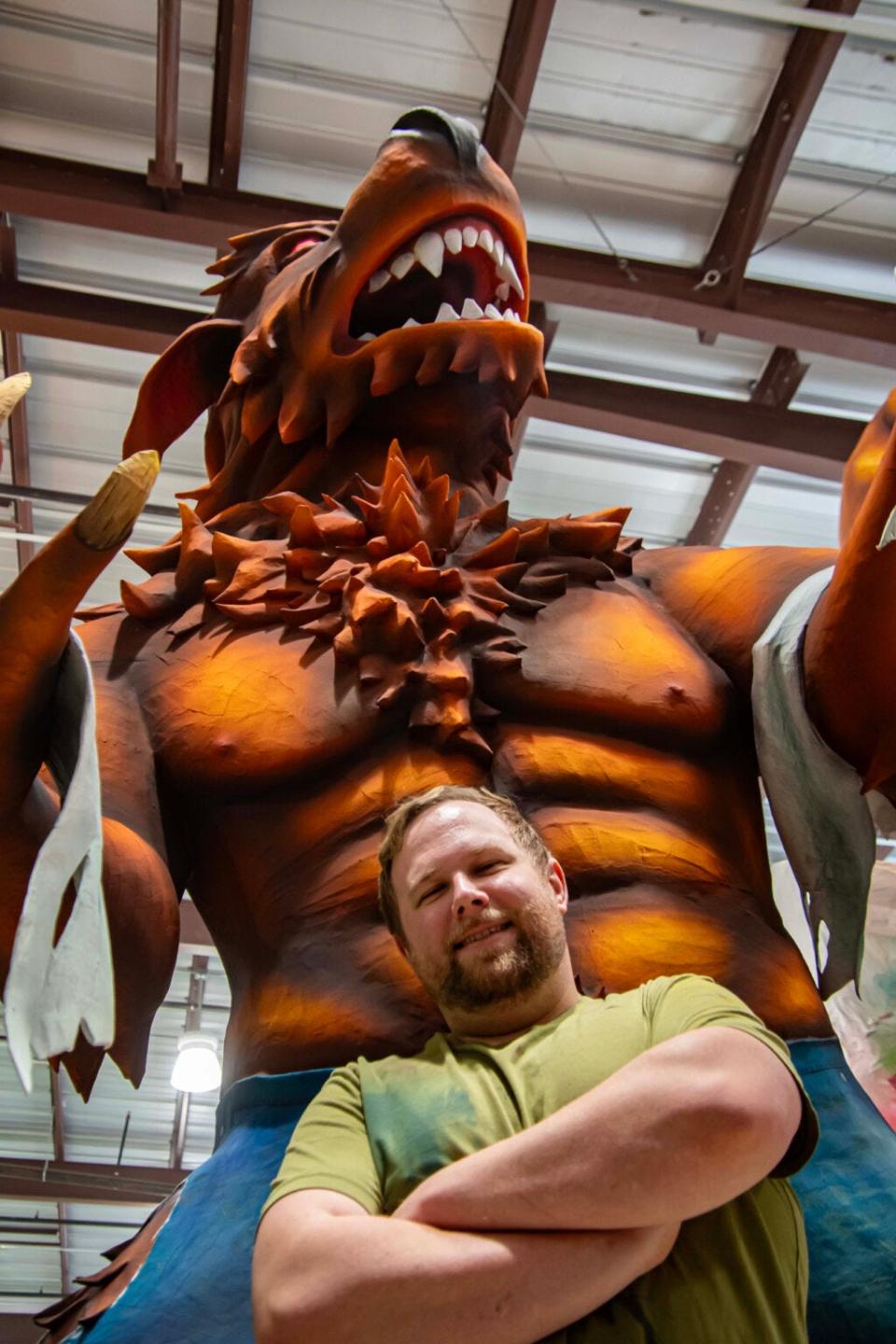 Ben Kaiser stands in front of the werewolf he designed for a Mardi Gras float.