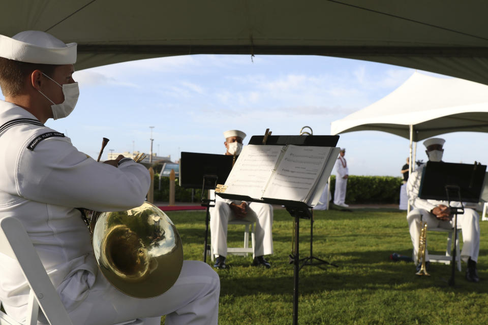 A U.S. Navy band sits during a ceremony to mark the anniversary of the attack on Pearl Harbor, Monday, Dec. 7, 2020, in Pearl Harbor, Hawaii. Officials gathered in Pearl Harbor to remember those killed in the 1941 Japanese attack, but public health measures adopted because of the coronavirus pandemic meant no survivors were present. The military broadcast video of the ceremony live online for survivors and members of the public to watch from afar. A moment of silence was held at 7:55 a.m., the same time the attack began 79 years ago. (AP Photo/Caleb Jones, Pool)