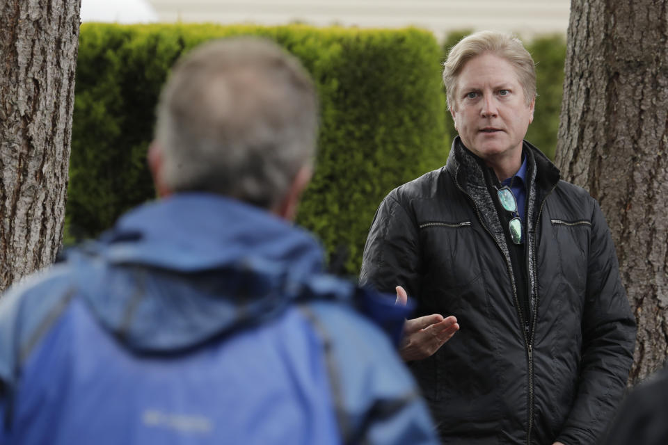 In this March 12, 2020, photo, Scott Sedlacek, left, who has tested positive for the COVID-19 coronavirus, listens as Tim Killian, right, a spokesman for Life Care Center in Kirkland, Wash., answers one of Sedlacek's questions during Killian's daily press briefing. Sedlacek's father, Chuck, who also has tested positive, lives in the facility, which has been at the center of the COVID-19 coronavirus outbreak in the state, and Sedlacek said he and his siblings have barely spoken to their father, who has blindness and neuropathy, and difficulty using a phone, saying he is more of an "inmate" than a patient. Residents of assisted living facilities and their loved ones are facing a grim situation as the coronavirus spreads across the country, placing elderly people especially at risk. (AP Photo/Ted S. Warren)