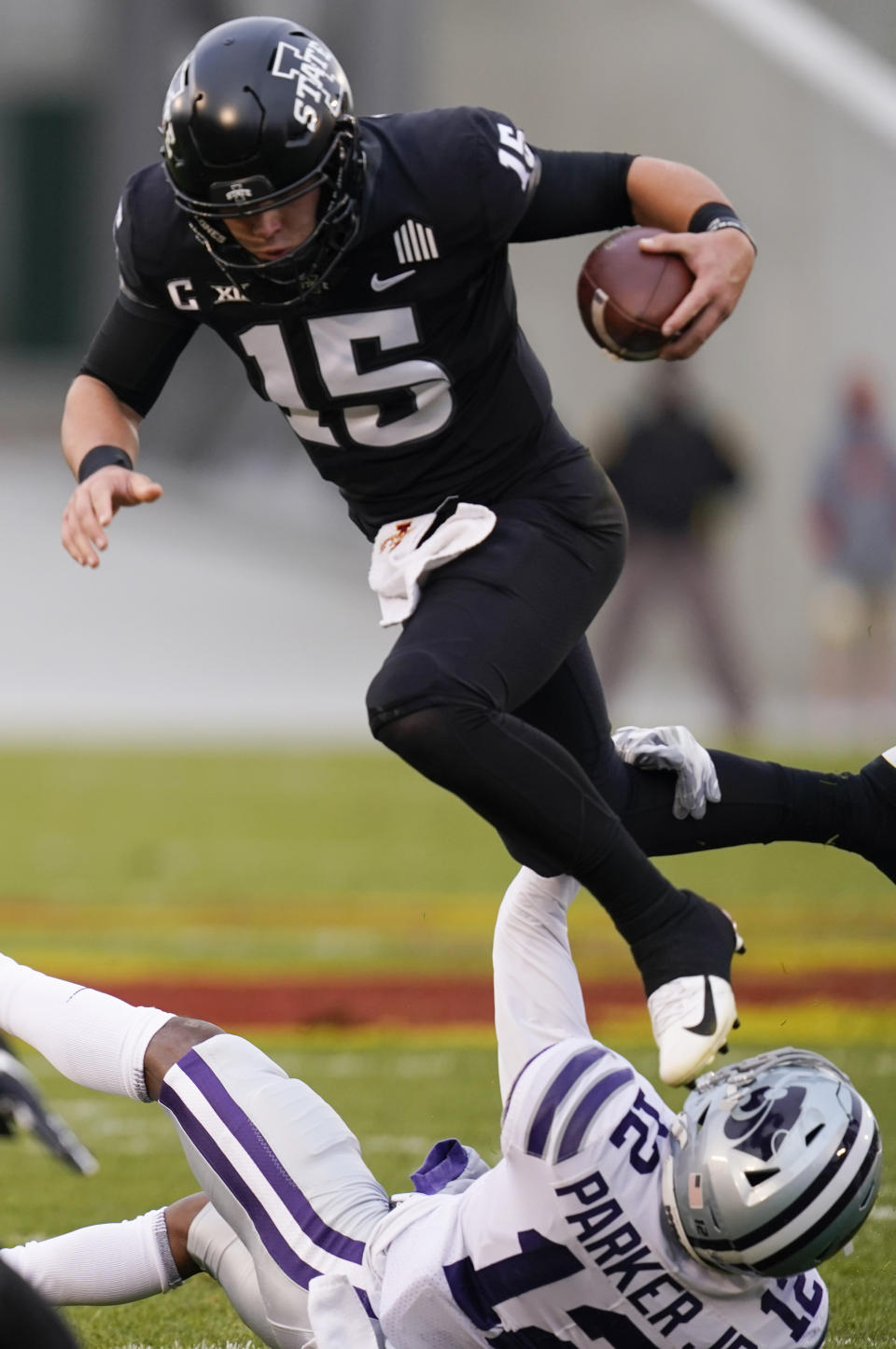 Iowa State quarterback Brock Purdy (15) leaps over Kansas State defensive back AJ Parker (12) during the first half of an NCAA college football game, Saturday, Nov. 21, 2020, in Ames, Iowa. (AP Photo/Charlie Neibergall)