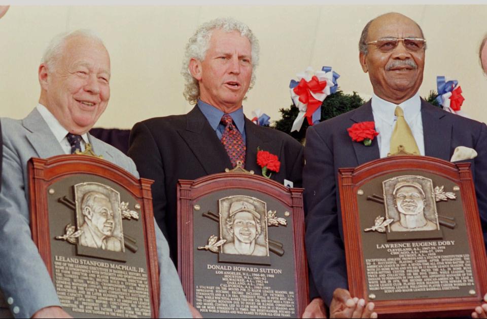 On the day of their induction into the Baseball Hall of Fame in Cooperstown, N.Y., the trio of (from left) Lee MacPhail Jr., Don Sutton and Larry Doby hold their plaques .