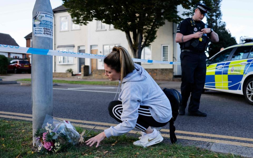 A member of the public leaves a bunch of flowers at a police cordon near the scene in Leigh-on-Sea - Photo by TOLGA AKMEN/AFP via Getty Images